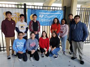 Students posing in front of our AP Capstone Diploma Banner 